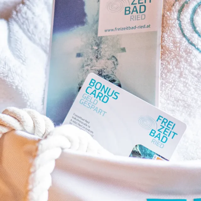 Detailaufnahme einer Badetasche mit Bonus Card, Handtuch und Flyer vom Freizeitbadried