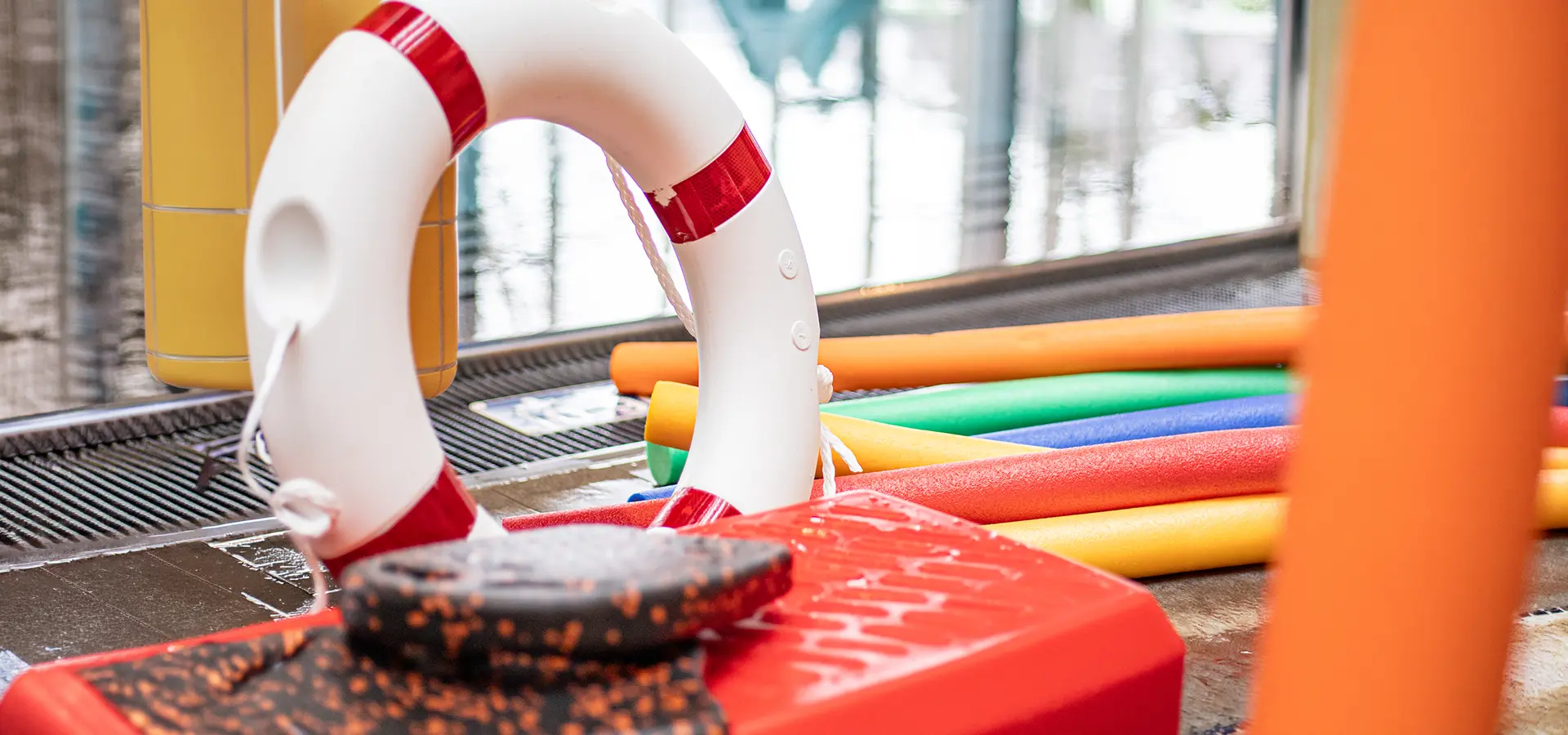 Rettungsring und Schwimmnudeln liegen am Beckenrand