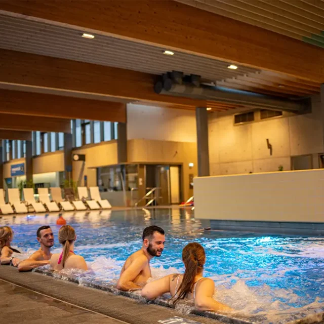 Gäste entspannen sich bei unseren Sitzen im Familienbecken mit Sprudelliegen und Schwalldusche.
