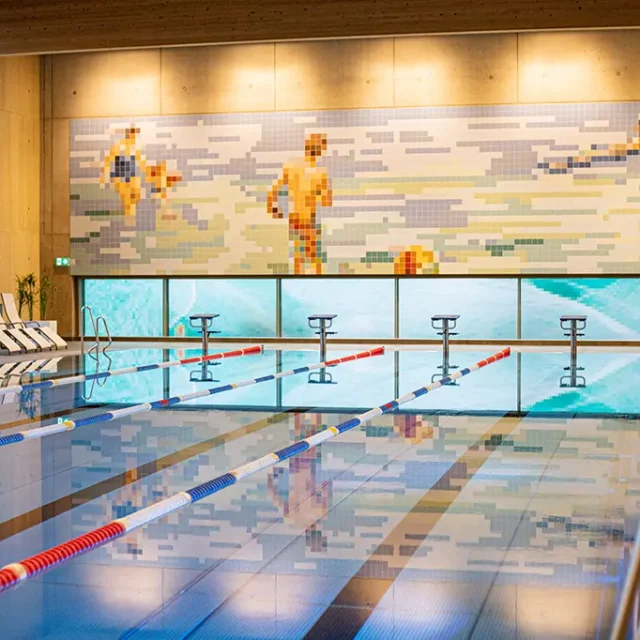 25 Meter Sportbecken. Es spiegelt sich das Wandbild im Wasser.