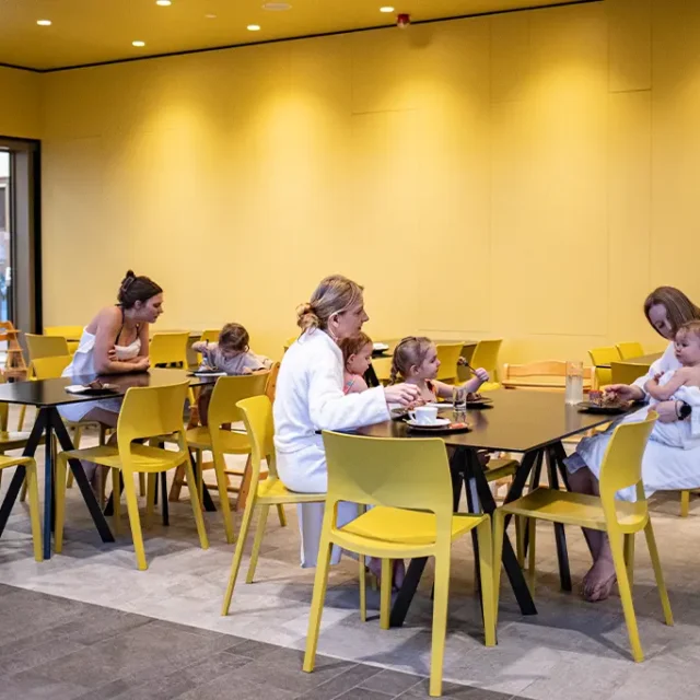 Badebistro mit Gästen auf Stühlen und Tischen