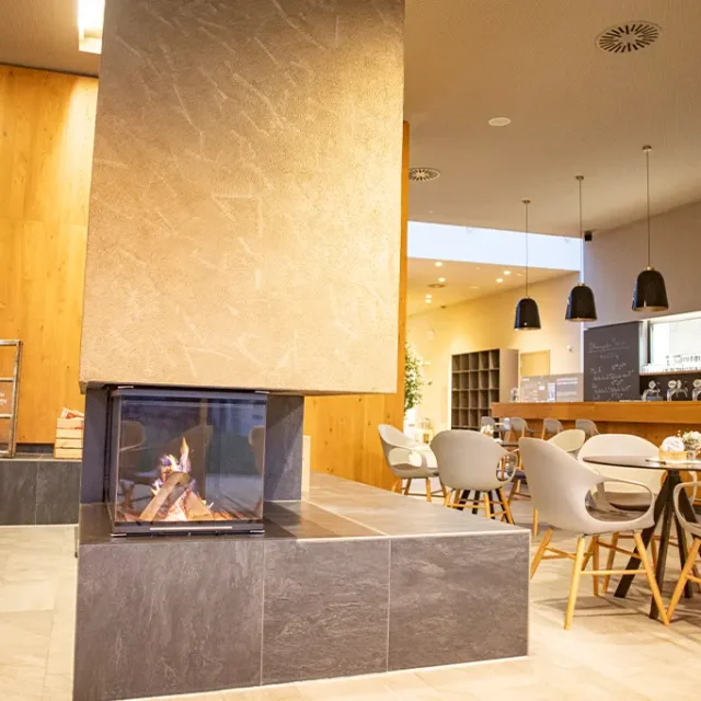 Saunaloung mit Blick auf Sitzmöglichkeiten, Kamin und Bar