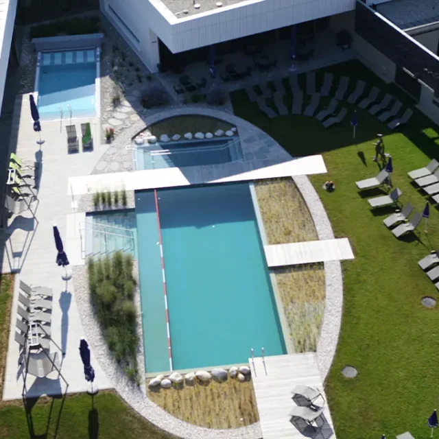 Vogelperspektive des Sauna-Außenbereichs mit Liegen und Schwimmbecken