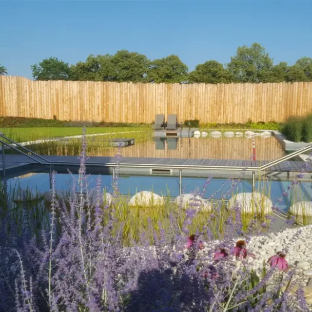 Der Sauna-Außenbereich mit Wiese, Becken und Steg im schön gestalteten Garten