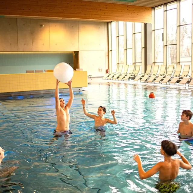 Kinder im Wasser spielen mit Wasserball