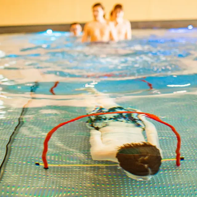 Kind taucht unter Wasser durch Ringe